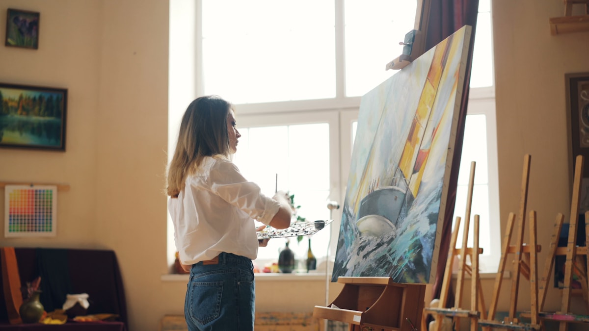 Artist painting in a bright studio