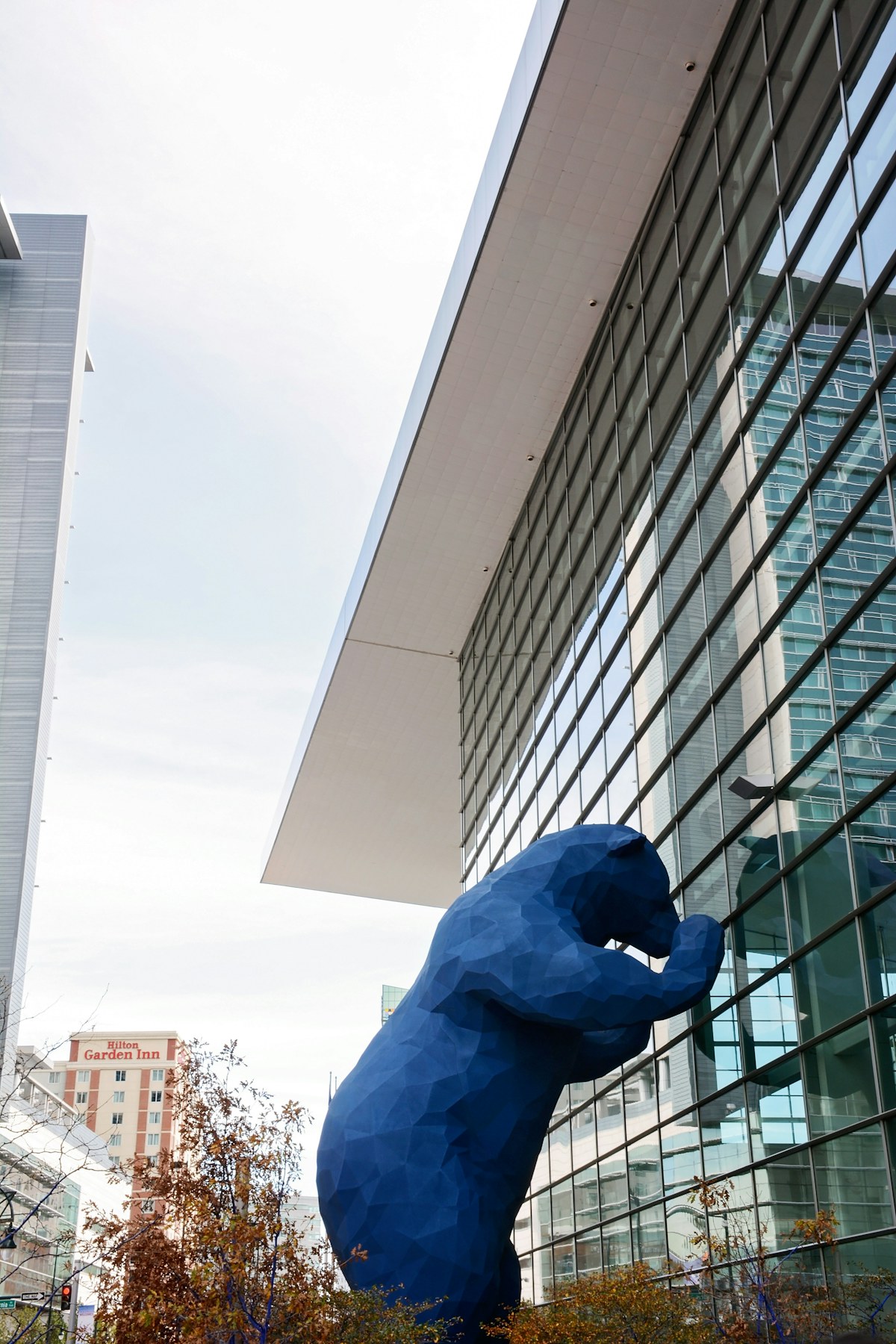 Large blue public sculpture beside a glass civic building